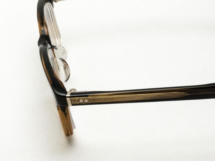 レンズとフレームの面を揃えたターニングステップ TP-310。テンプル合口のメタルパーツがアクセント。