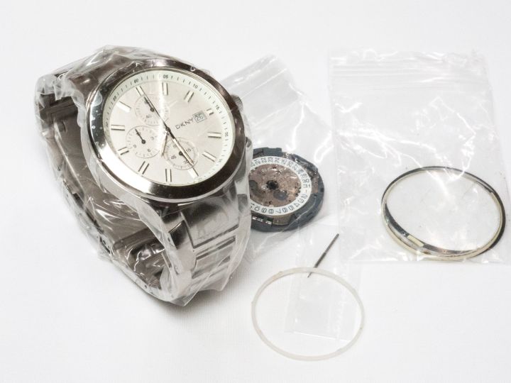 島根県松江市で修理完了したDKNY NY-5045と交換したムーブメント、ガラス風防、裏蓋パッキンの写真。新品に近い輝きを取り戻した時計。